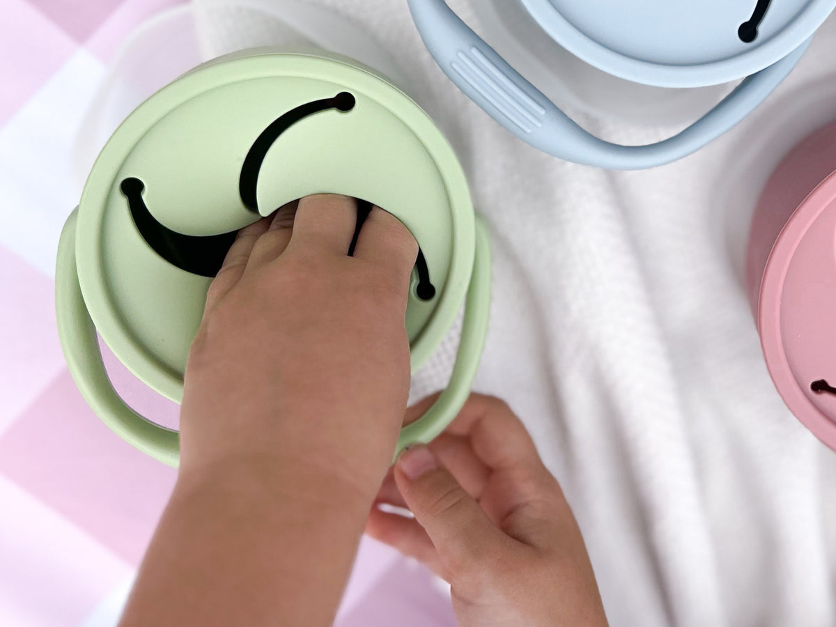 Kleine Hand greift durch den Deckel der Snackbox